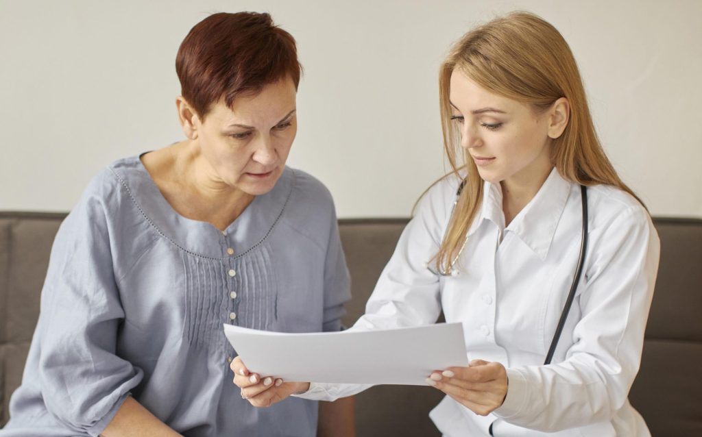 Divas sievietes, kas kopīgi apspriež holesterīna anlīzes